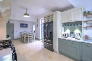 eine Küche mit blauen Schränken und einem schwarzen Kühlschrank in der Unterkunft Fabulously Unique 3BD Home Sunderland in Sunderland