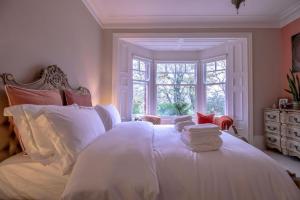 een slaapkamer met een bed met witte lakens en een raam bij Fabulously Unique 3BD Home Sunderland in Sunderland