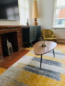- un salon avec une table basse et une cheminée dans l'établissement Elegant 3BD Edwardian Home Warminster, à Warminster