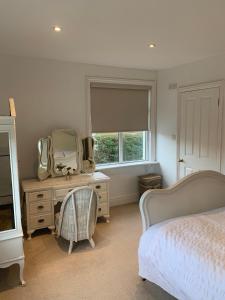 a bedroom with a bed and a dresser and a mirror at Elegant 3BD Edwardian Home Warminster in Warminster