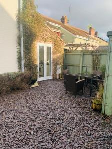 a patio with a table and chairs next to a house at Elegant 3BD Edwardian Home Warminster in Warminster