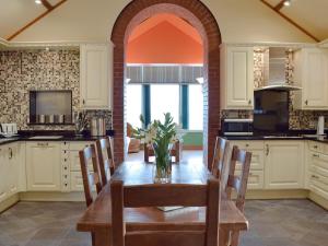 una cocina con una mesa de madera con sillas y una ventana en Elm Cottage-w40630 en Gelliwen