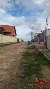 un camino de tierra vacío con un edificio y una casa en Casa de praia da maria Luiza, en Barra de São Miguel