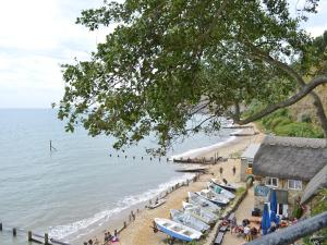 una playa con un montón de barcos y gente en ella en Chine Bluff, en Shanklin