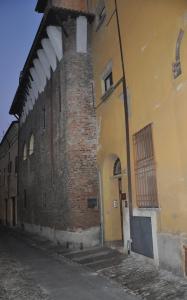 een oud bakstenen gebouw met een boog naast een straat bij La Mainolda B&B in Mantova