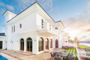 a white house with a patio and a pool at LUX The White Palm Villa in Dubai