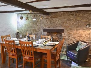 a dining room with a wooden table and chairs at Bwthyn Barri in Sarnau
