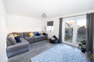 a living room with a couch and a sliding glass door at Immaculate 3 Bedroom Home Barnstaple Devon in Barnstaple