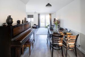 バーンスタプルにあるImmaculate 3 Bedroom Home Barnstaple Devonのダイニングルーム(テーブル、ピアノ付)