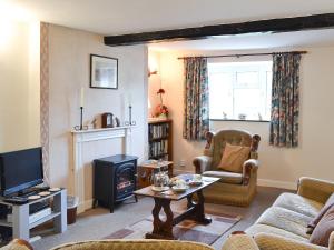 a living room with a couch and a tv at Upper Ffinnant in Aber-Brân