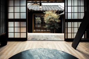uma entrada para um edifício com janelas e uma mesa em Oito 美しい街並みに佇む喫茶と宿 em Tamba-sasayama