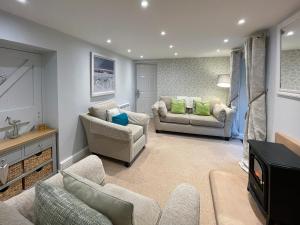 a living room with two couches and a tv at Riverview Cottage in Hartington