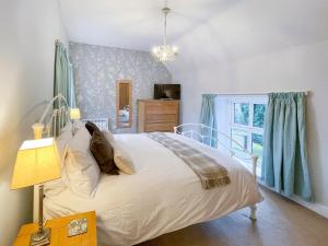 a bedroom with a bed and a window at Riverview Cottage in Hartington