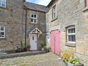 a brick building with a red door and a white door at Riverview Cottage in Hartington