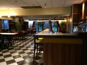 eine Bar in einem Restaurant mit Tischen und Stühlen in der Unterkunft Kyriad Argenteuil in Argenteuil