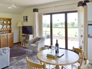 Sala de estar con mesa y botella de vino en Weetwood Lodge en Kelsall