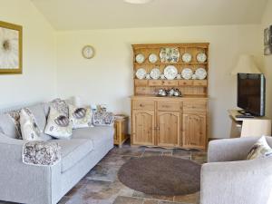 a living room with a couch and a tv at Weetwood Lodge in Kelsall