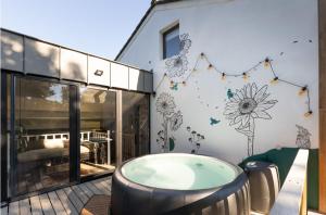 a patio with a jacuzzi tub and a bedroom at Marie à la Campagne in Dolembreux