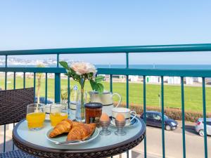 a table with breakfast foods and drinks on a balcony at 8 Belvedere Court in Paignton