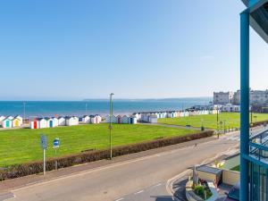 a view of a street with beach huts and the ocean at 8 Belvedere Court in Paignton