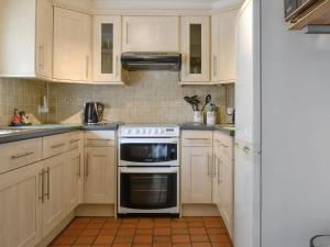 - une cuisine avec des placards blancs et une cuisinière dans l'établissement Crossgates - 9562, à Grantley