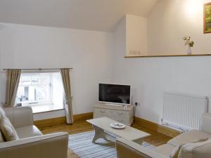 uma sala de estar com um sofá e uma televisão em The Loft - 26477 em North Willingham