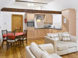 cocina y sala de estar con mesa y sofá en The Loft - 26477, en North Willingham