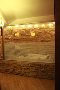 uma grande parede de tijolos com uma banheira num quarto em Hotel Ginepro em Qualiano