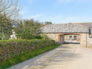 a stone house with a garage and a stone wall at Trescowthick Barn in Zelah
