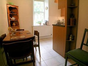 uma cozinha com mesa e cadeiras num quarto em Glencoe Cottage em Glencoe