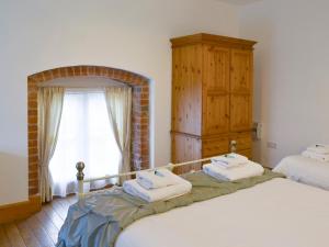 um quarto com 2 camas individuais e uma janela em The Granary Barn - 25589 em North Willingham