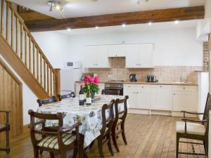 uma cozinha com uma mesa com flores em The Granary Barn - 25589 em North Willingham