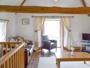 - un salon avec un canapé et une chaise dans l'établissement The Granary Barn - 25589, à North Willingham