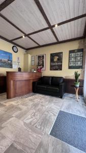 uma sala de espera com um sofá e um relógio em Nuova Locanda Belvedere em Marghera