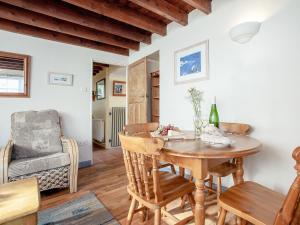 a dining room with a table and a chair at Bowjy Cottage in Cubert