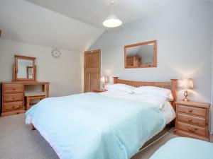 a bedroom with two beds and a mirror and two tables at Bowjy Cottage in Cubert