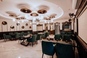 a dining room with tables and green chairs at Bajaj's Karwan Inn in Jagdalpur