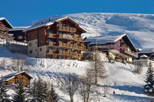 un hotel en la cima de una montaña cubierta de nieve en Hotel Bellwald en Bellwald