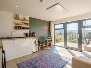 a kitchen with a large window and a table with chairs at Skye Eco Pod in Port na Long