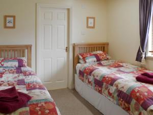 two beds sitting next to each other in a bedroom at Woodpeckers Cabin in Bridlington