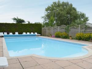a swimming pool with chairs and a fence at Pine Cottage in Cote