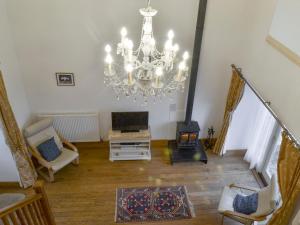 a living room with a chandelier and a fireplace at The Hay Barn- 26724 in North Willingham