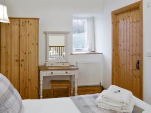 a bedroom with a table and a mirror and a bed at The Hay Barn- 26724 in North Willingham