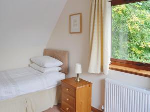 Habitación pequeña con cama y ventana en Lime Tree Cottage, en Oakley