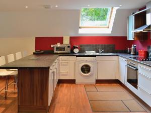 a kitchen with a washer and dryer in it at Lime Tree Cottage in Oakley