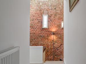 uma parede de tijolos ao lado de uma escada com uma janela em The Mistress House em Hunstanton