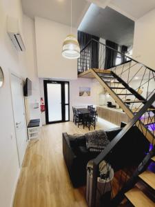 a living room with a black couch and a spiral staircase at Grandera Apart`s - Carbonell 1 in Valencia