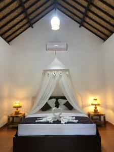 una camera con un letto a baldacchino bianco di Cewin's Homestay a Kuta Lombok