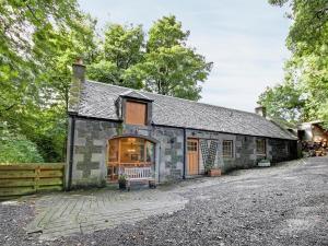 an old stone house with a garage at Coach House in Ratho