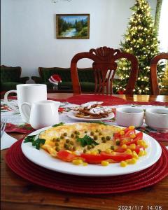 a plate of food on a table with a christmas tree at Sweet Vibe Home in Almaty